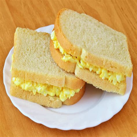 Transfer the eggs to a bowl. To assemble the sandwiches, spread about 1 teaspoon of the mustard over the cut-side of each croissant bottom. Place a slice of ham over the bottom piece of each croissant. Top each with a heaping 1/2 cup of scrambled eggs and 1/4 cup of cheese. Place the top half of each croissant over the sandwich.